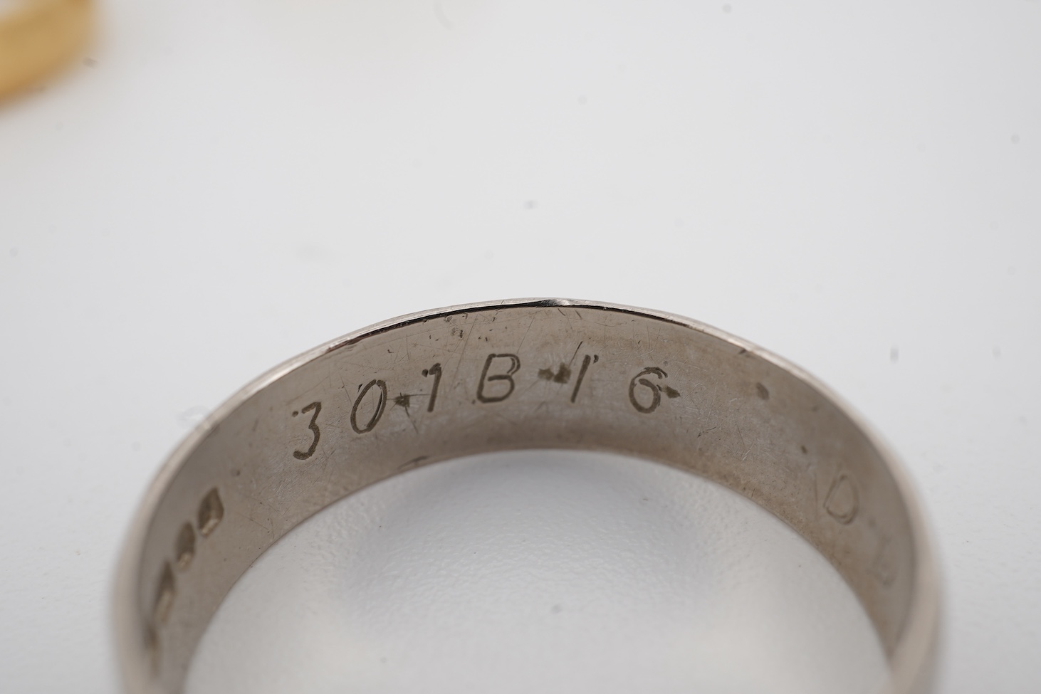 A 1990's 18ct gold wedding band, with engraved inscription, size U/V, a similar signet ring with engraved monogram and inscription, size I and an early 1970's 18ct white gold band, size O, gross weight 15.4 grams.